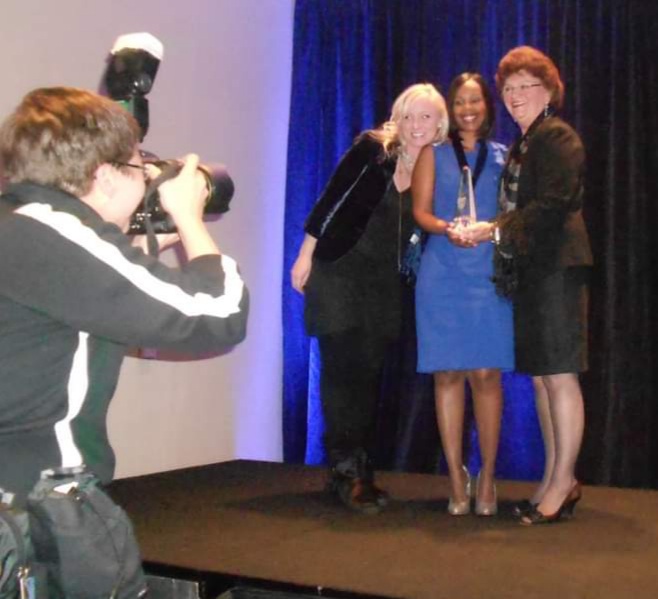 Summer Owens receiving the University of Memphis Distinguished Alumni Award from Dana Gabrion and Anita Vaughan